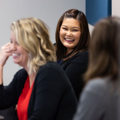 This is an image of three coworkers all talking and laughing with one another