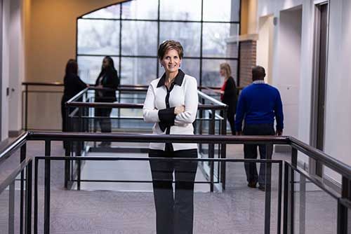 Image of one of our retail bankers standing in the QCBT building smiling towards the camera